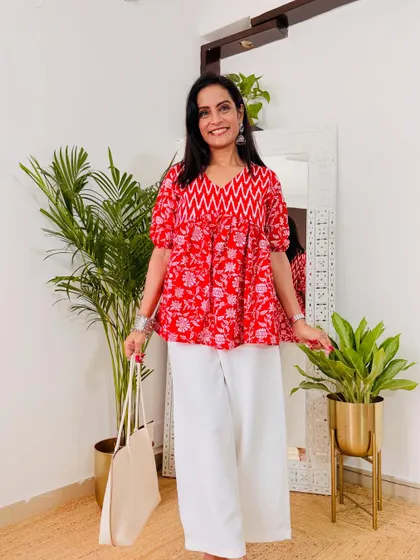 This red printed peplum top is so cute and festive. Paired with white trousers, it makes for a great semi-formal or casual festive look.