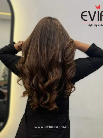 This client is showing off her fresh balayage, with perfectly blended tones and voluminous curls. The color placement makes her hair look incredibly thick and healthy.