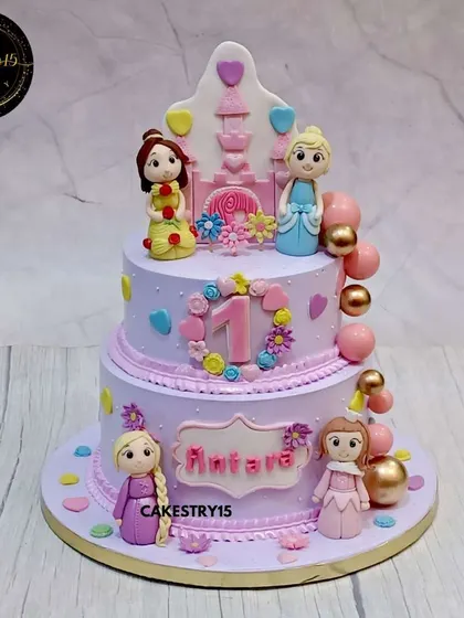 This two-tier blueberry cake is a royal fairytale for a first birthday. It features fondant figures of beloved princesses, a castle silhouette, and soft pastel colors for a truly enchanting look.