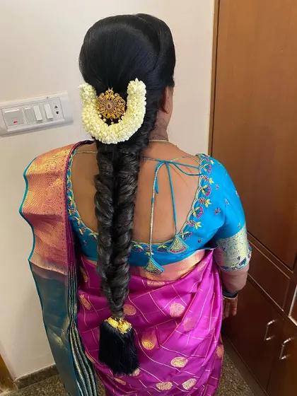 An elegant fishtail braid for a non-bridal client. This style is adorned with a jasmine gajra and a single gold hairpin, making it perfect for a wedding guest.