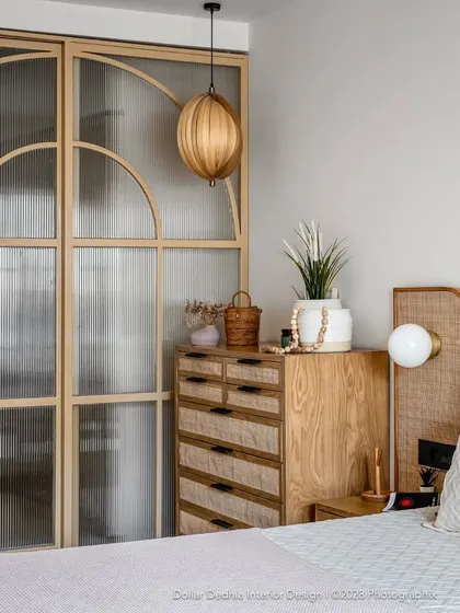 This bedroom showcases a Japandi-inspired aesthetic, blending natural wood, rattan, and fluted glass. It’s a perfect example of how I create calm, uncluttered sanctuaries that are full of texture and warmth.