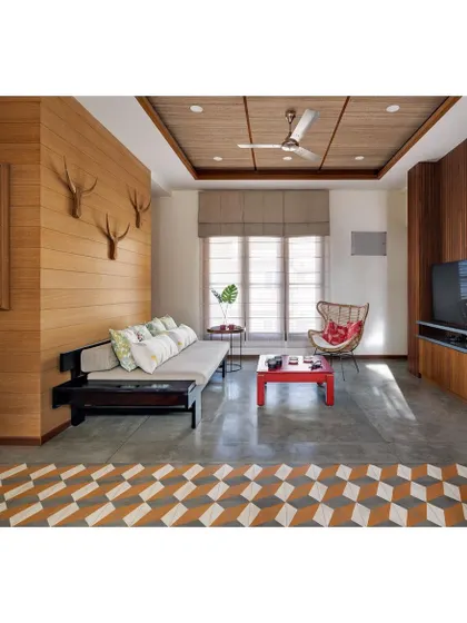The informal living area in the Nataraj House, with its Indian daybed (divan), polished cement flooring, and banana fiber ceiling. The space is designed for comfort and warmth, reflecting an earthy, tropical aesthetic.