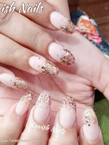 A warm and festive design featuring a soft pink base with a fade of chunky gold glitter from the tips.