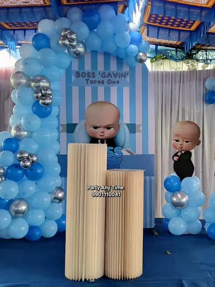 A fun Boss Baby theme for a first birthday, with character cutouts and a blue and silver balloon arch.