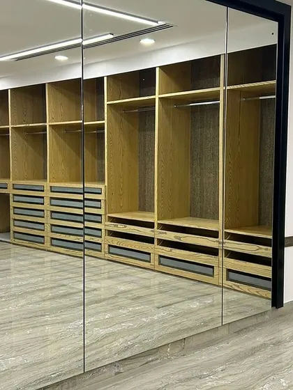 We used full-length mirrors as wardrobe doors in this walk-in closet. This not only provides a practical dressing solution but also visually doubles the size of the space, making it feel even more expansive.