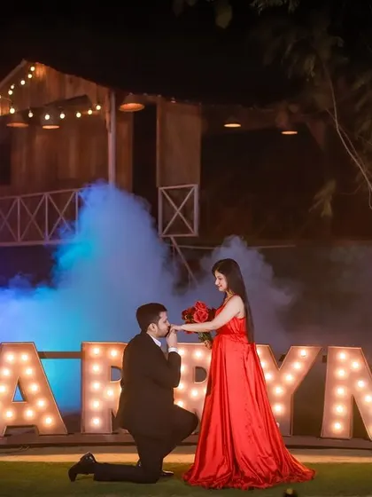 Unforgettable Night Shoots. Make a grand statement with our magical night setups. Using dramatic props like these 'MARRY ME' marquee letters, along with professional lighting and smoke effects, we help you create truly cinematic memories.