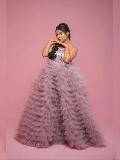 A full-length portrait showcasing the impressive volume of the purple net gown.