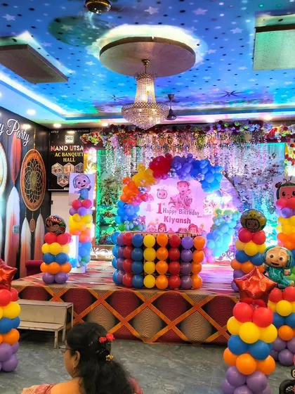 This is how I turn a banquet hall into a child's wonderland! A vibrant, large-scale Cocomelon theme for a first birthday party, complete with a multi-colored stage setup, character cutouts, and towering balloon columns.