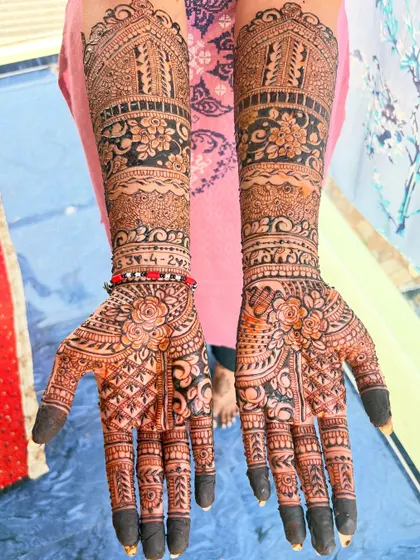 A lovely bridal design with a mix of different elements, including floral motifs on the palm and architectural dome patterns on the forearm.