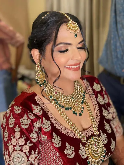 The perfect blend of tradition and personal style. Nutisha's makeup features a classic winged liner and a warm, rosy blush that enhances her joyful expression.