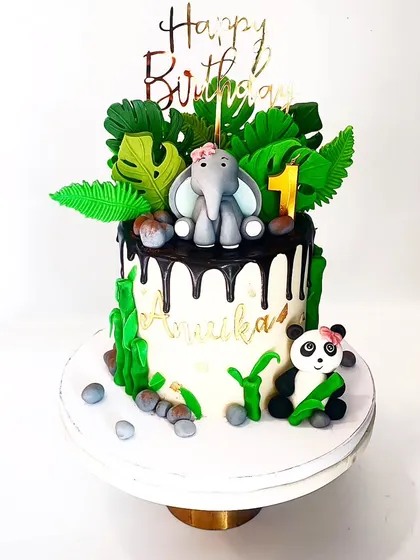 A sweet and simple jungle theme cake for an intimate first birthday. This design features a cute elephant and panda, the birthday girl's favorite animals, with a rich chocolate drip.