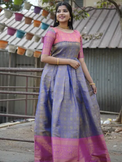 A full-length view of a beautiful long gown made from upcycled silk saree fabric. The combination of lavender and pink with a traditional border makes it a unique and sustainable ethnic outfit.