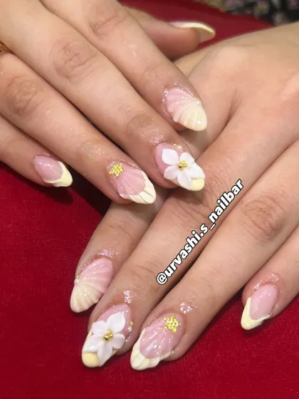 This elegant set features sculpted shell textures on the tips and hand-crafted 3D florals with tiny gold accents. The combination of textures on a soft blush base creates a truly sophisticated and artistic look.