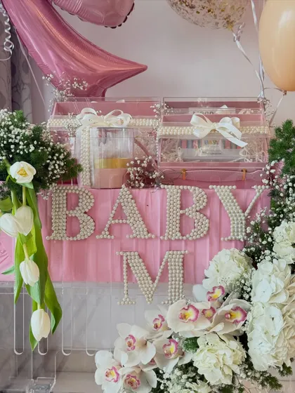 A close-up of the 'Baby M' hamper, showing the pearl-studded lettering and luxurious floral arrangement for the Malhotra baby.