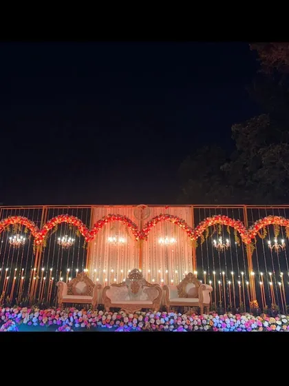 This is how we set the stage for a grand reception in Lonavala. The elegant gold-arched backdrop, sparkling chandeliers, and warm lighting created a royal ambiance for the couple's big night.