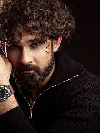 A powerful male portrait with dramatic, low-key lighting. The dark background and intense gaze create a moody and cinematic headshot, showcasing the model's versatility.