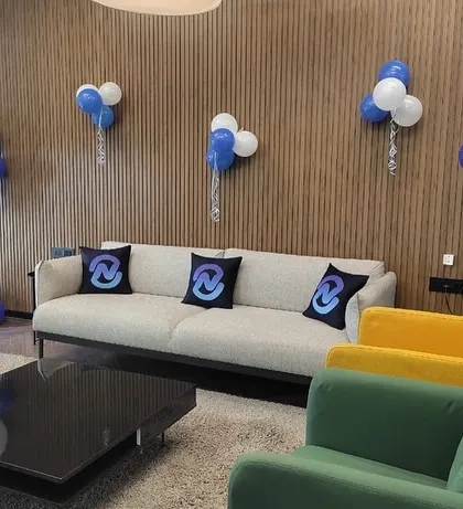 A stylish and branded lounge area for a corporate event. We provided custom logo-printed pillows for the couches and placed personalized balloon bouquets around the room to reinforce the company's brand identity during the celebration.