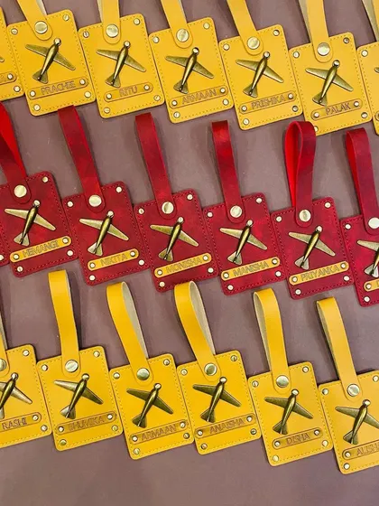 A closer look at our red and yellow personalised luggage tags. The antique brass airplane charm adds a vintage touch.