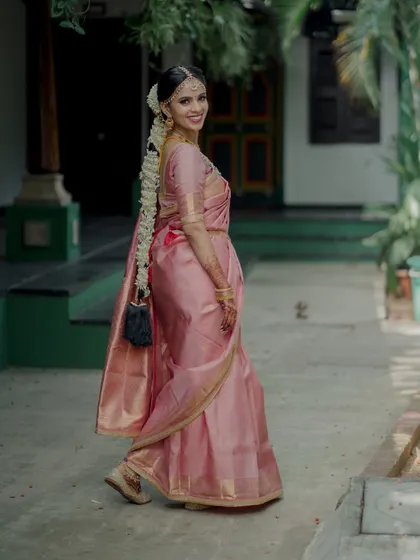 A candid shot of the bride as she walks through the venue's traditional courtyard. Her smile captures the excitement and happiness of the day.