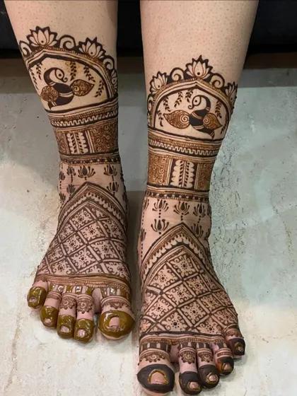 A beautiful foot design with peacock motifs inside a jharokha, giving it a royal and elegant feel.