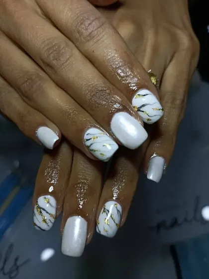 Another look at the white marble nails, showing the full set. The combination of solid white and marbled nails creates a balanced and stylish look.
