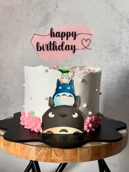A simple and happy cake featuring characters from My Neighbor Totoro. The clean design and cute toppers make it a cheerful celebration cake.