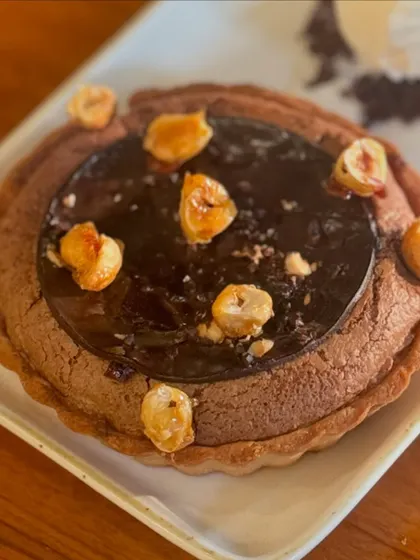 Our Dark Chocolate Soufflé Tart, topped with toasted hazelnuts. A deep, intense chocolate experience.