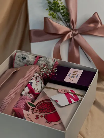 A closer look inside one of the Women's Day boxes. Each item is carefully chosen and arranged, from the floral scarf and makeup pouch to the custom-branded card and treats.