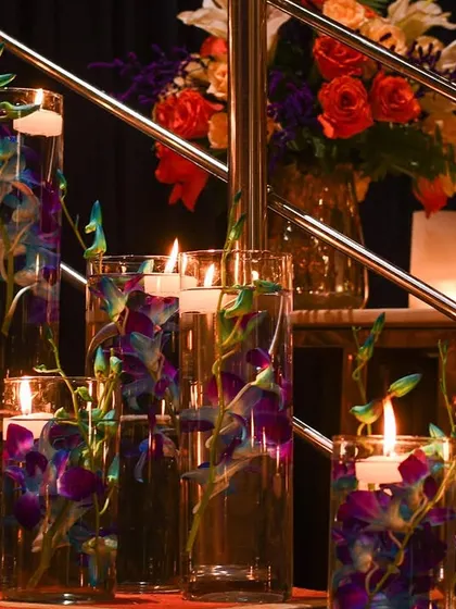 Floating candles and submerged orchids in tall glass cylinders create a modern and elegant decor element. This is a beautiful way to add color and light to spaces like stairways or entrance halls.