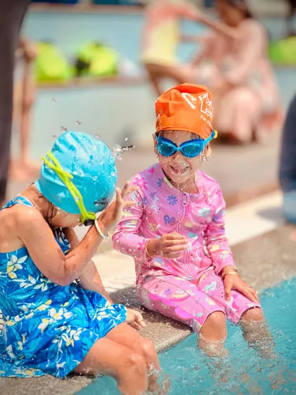 A series of candid shots showing a young swimmer's journey of getting comfortable at the pool's edge. From happy claps to playful splashes, it's all part of the learning process.