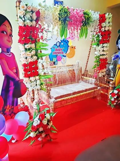 This is a compact yet vibrant baby shower decoration perfect for home functions. It includes the essential decorated jhula, character cutouts, and hanging floral arrangements to create a festive corner in your house.