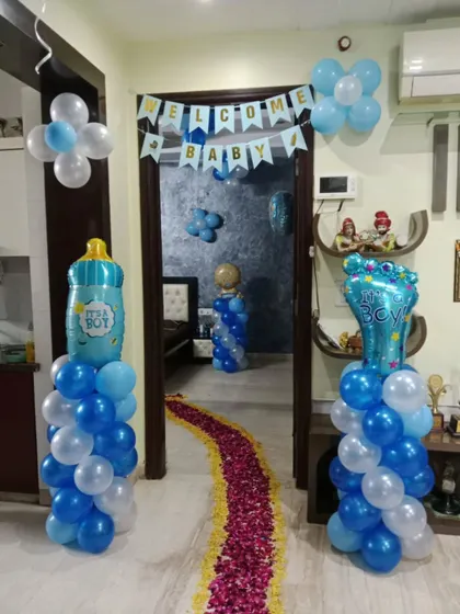 Balloon pillars with "It's a Boy" foil toppers and a rose petal walkway create an inviting entrance for the new baby.