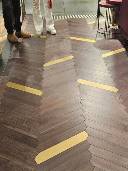 A unique wooden floor design with brass inlay accents, creating a path-like effect. This is the pinnacle of bespoke, luxury flooring.