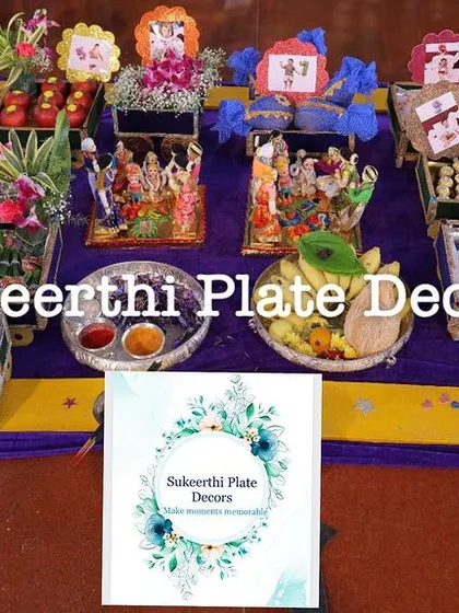 A colorful and traditional platter arrangement for an ear-piercing ceremony. The setup includes deities, decorated fruits, sweets, and other auspicious items.