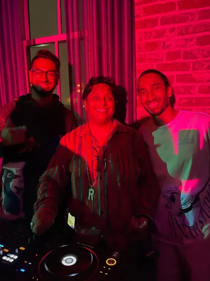 Posing with friends behind the decks at a private event. These gigs are often about celebrating with a close-knit community.