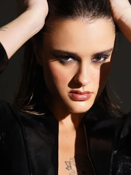 A direct and powerful gaze. This shot highlights the bold, blocky shape of the smokey eye makeup, creating a fierce and confident look that is pure high fashion.