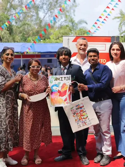 Winners of a competition proudly pose with their prizes and our directors at the Francophonie Mela. It's a moment of achievement and recognition, highlighting the interactive fun of our cultural festivals.