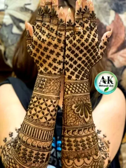 A bride showcasing her full-arm mehndi, which features a dense jaal pattern on the back of the hands.