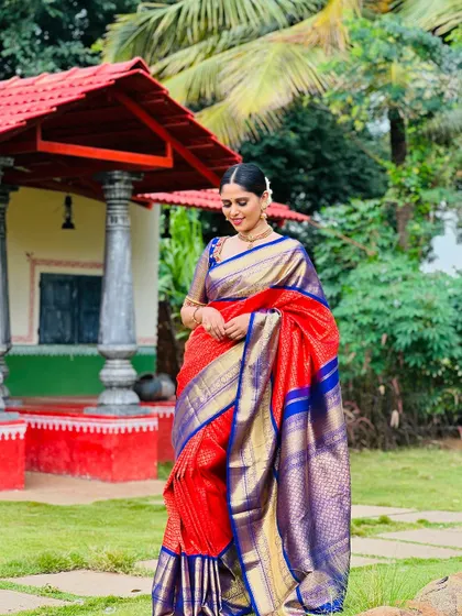 A full-length view of me in the red and blue saree, standing in a traditional setting.