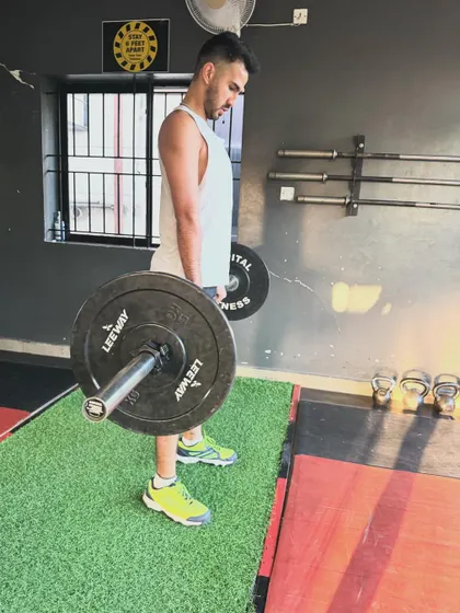 A client executes a deadlift, a full-body exercise that is central to our strength programs.