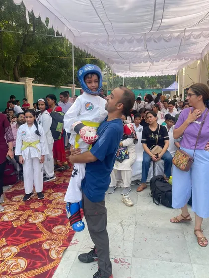 Lifting a young student after his event. Supporting my athletes, especially the youngest ones, is a key part of my role as a coach.