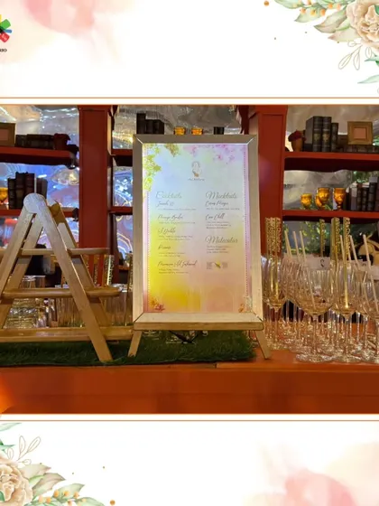 A custom menu on an easel, set against a backdrop of elegant glassware. We design menus that are both informative and a beautiful part of the decor.