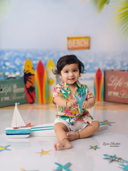 A fun and vibrant beach-themed milestone shoot. This little boy in a Hawaiian shirt is ready for some sun and sand.