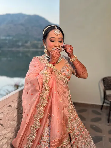A candid moment of the bride adjusting her nose ring. Her makeup looks flawless and natural, even in unposed shots.
