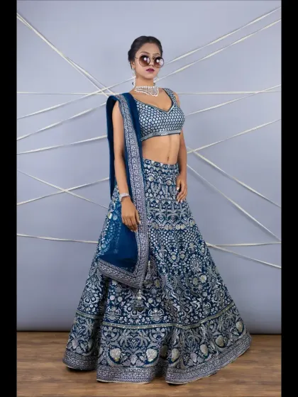 A full-length shot of the navy blue lehenga with heavy silver embroidery. The rich color and intricate work make it a perfect choice for a reception or sangeet.