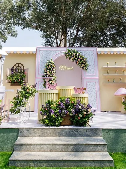 A wide shot of Maanvi's stunning flower garden party. The setup features a charming flower bar, a beautifully decorated cake stage, and oversized floral props, all designed to create a whimsical, interactive experience.