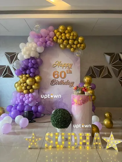 An elegant 60th birthday celebration with purple, white, and gold decor.