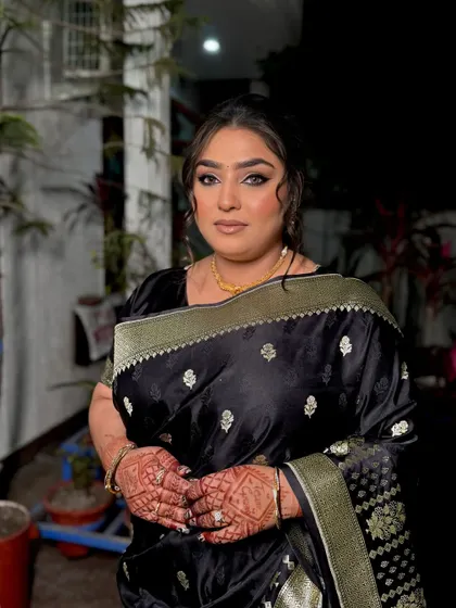 Another shot of this stunning black saree look. The focus is on the dramatic eye makeup, which adds a touch of glamour perfect for an evening reception or party.
