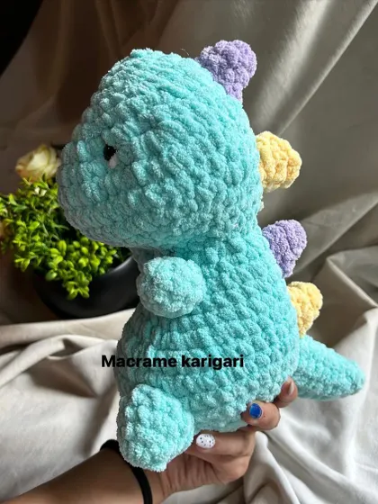 Our crochet dinosaur features soft pastel-colored spikes on its back, adding a playful touch. It's a unique handmade toy for any dino-loving kid.