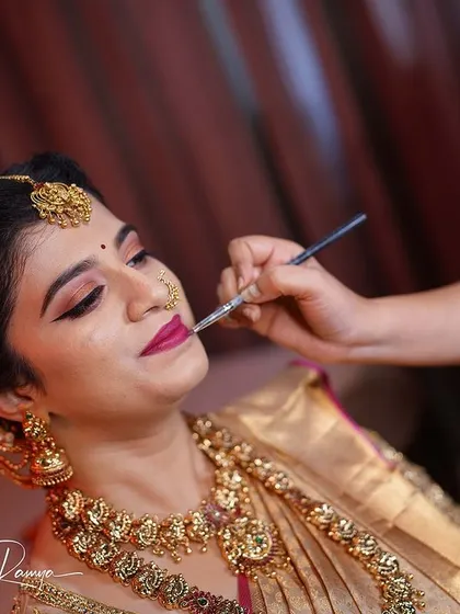 Adding the final touch of lipstick for bride Meghana. This moment captures the last step before she is ready for her wedding ceremony.